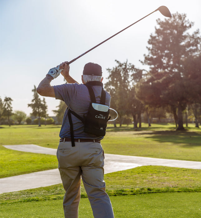 Man using CAIRE FreeStyle Comfort Portable Oxygen Concentrator while golfing
