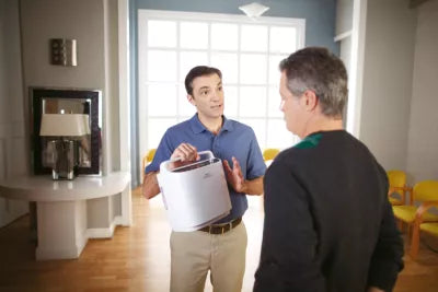 Man showing Respironics SimplyGo Portable Oxygen Concentrator to another man